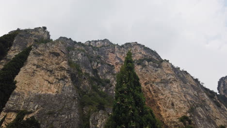 Toma-Panorámica-Vertical-Sobre-La-Línea-Montañosa-áspera-Y-Acantilada-En-Un-Día-Ventoso