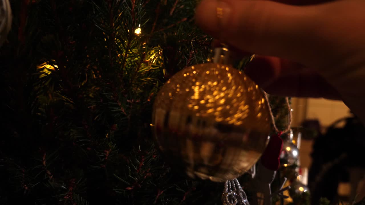 Famiglia che decora l'albero di Natale - primo piano delle mani di adulti e bambini che aiutano.