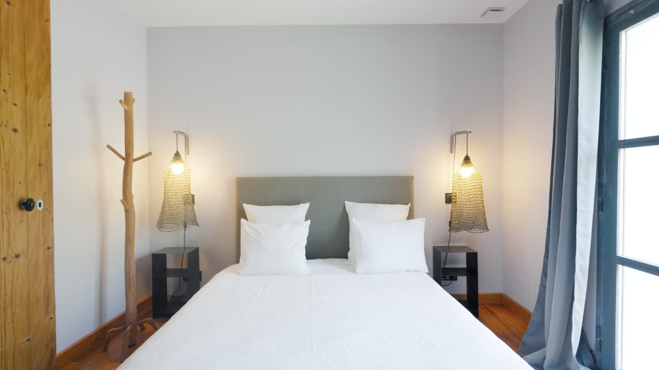 disparo de descenso lento de un dormitorio con armarios simétricos junto a la cama