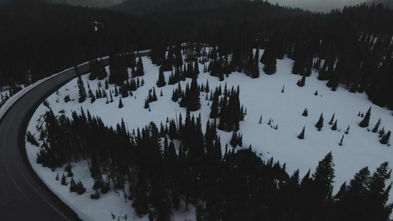 Aerial drone shot flying over the snowy mountains of Mount Rainier during winter, showcasing a vast white landscape