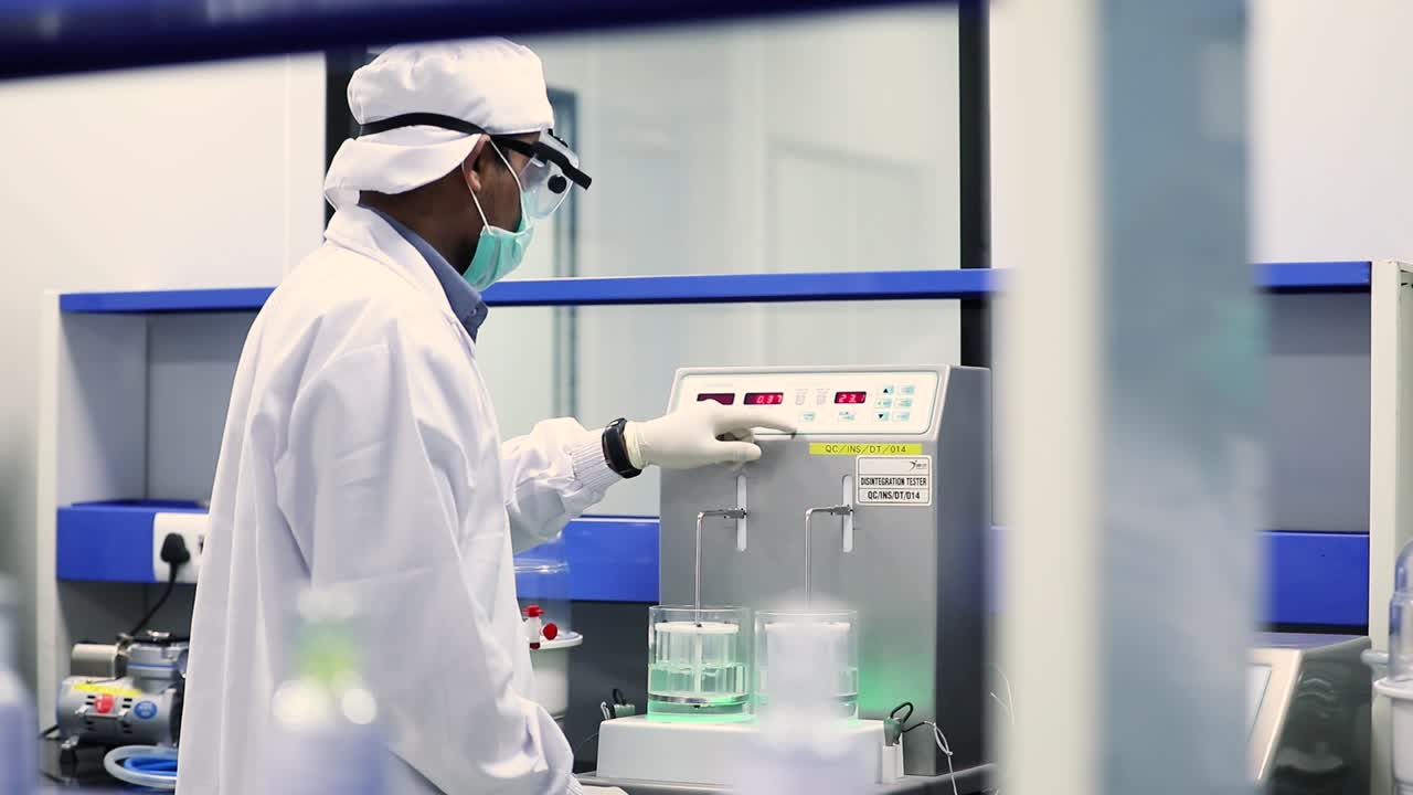 Doctor checks a distillation machine.