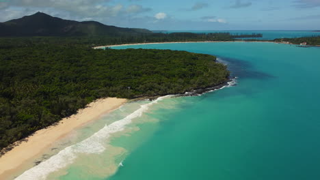 the isle of pines' beaches at bay of rouleaux in the foreground with the beach at kuto bay in the background - pull back aerial reveal