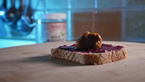 Putting-Spoonful-Of-Peanut-Butter-Onto-Whole-Grain-Bread-With-Fruit-Jelly