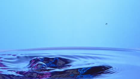 Close-up-of-a-thrown-ice-cube-that-splashes-through-purple-water