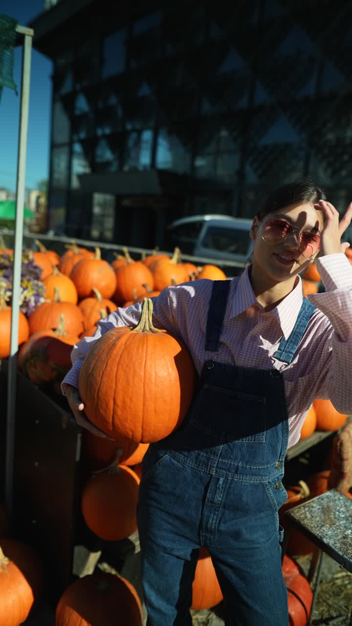 가을 농부 시장 에서 호박 을 들고 있는 여자