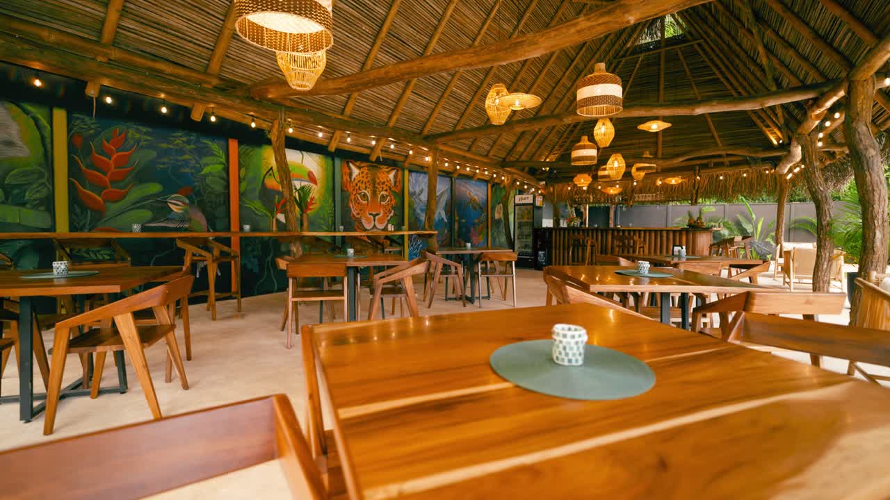 Bar de Restaurante Tropical Vazio com Murais Vibrantes de Selva e Teto de Palha