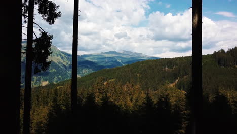 Drone-Volando-Fuera-Del-Hermoso-Bosque-De-Montaña-Hacia-El-Cielo-Azul