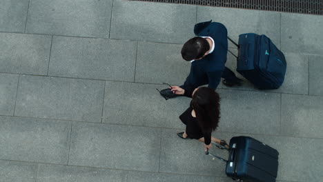 Top-view-couple-walking-with-suitcases.-Business-couple-talking-together