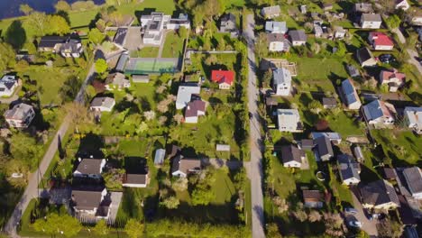 top-down to dolly-forward aerial view over river, forest, and neighborhood