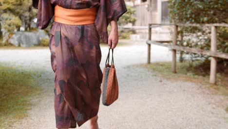 Slide-shot-of-person-walking-in-a-Hakama-in-front-of-a-temple-in-Kyoto,-Japan-4K-slow-motion