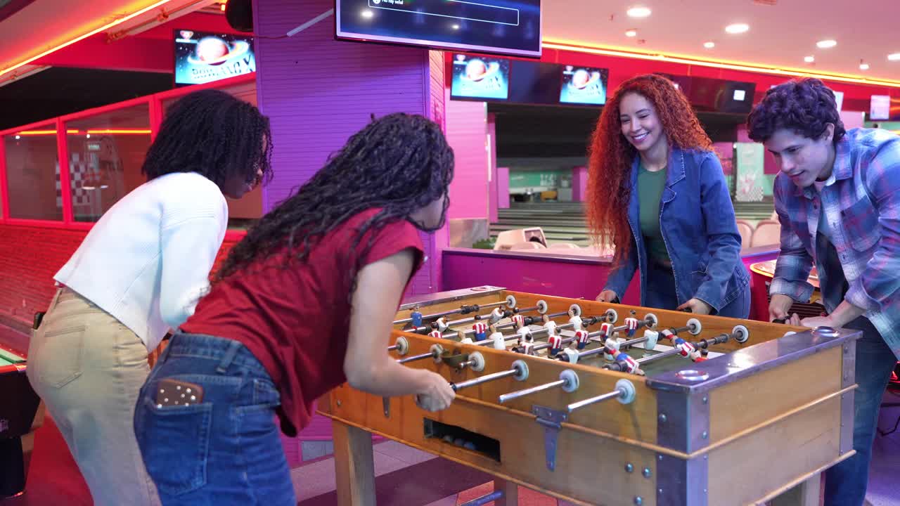 Pessoas jogando futebol de mesa em local fechado