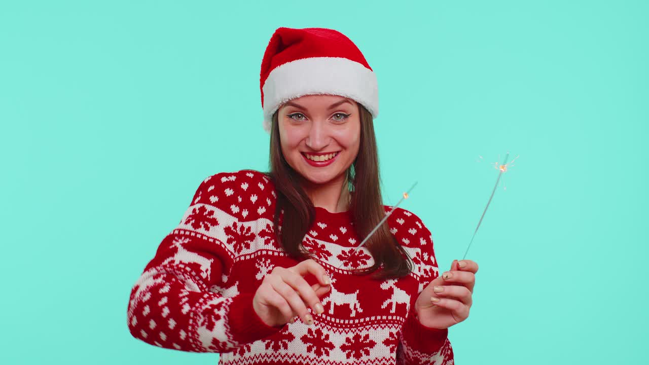 Lovely girl in christmas santa sweater dancing with bengal sparklers fireworks ligts congratulation