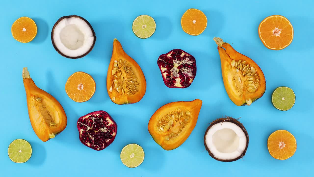 Slices of ripe fresh fruits move on blue theme. Stop motion