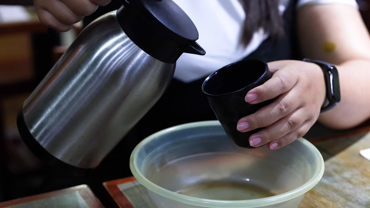 한 사람 이 테르모스 에서 물 을 그 에 부어 놓는다