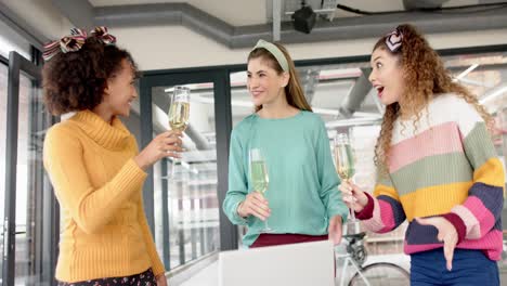Happy-diverse-businesswomen-celebrating-with-glasses-of-champagne-in-office-in-slow-motion
