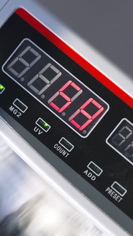 electronic cash counting equipment working. unrecognized banknotes turning quickly in machine. close up. vertical video