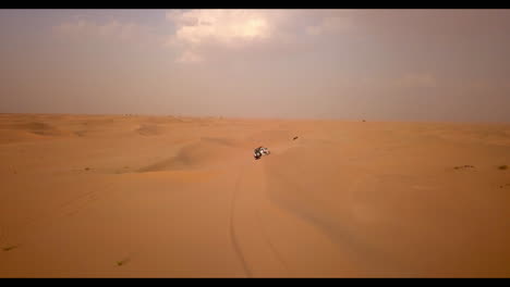 Aerial-view-of-two-trucks-on-an-extreme-dune-bashing-competition-in-the-desert