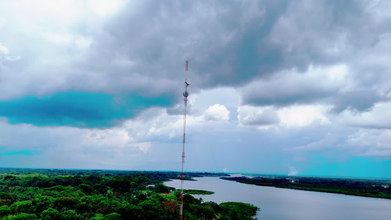 Orbita aerea intorno a una torre di comunicazione al servizio delle comunità in Amazzonia, Brasile, circondata da corsi d'acqua fluviali ed evidenziando connettività, infrastrutture e paesaggi remoti