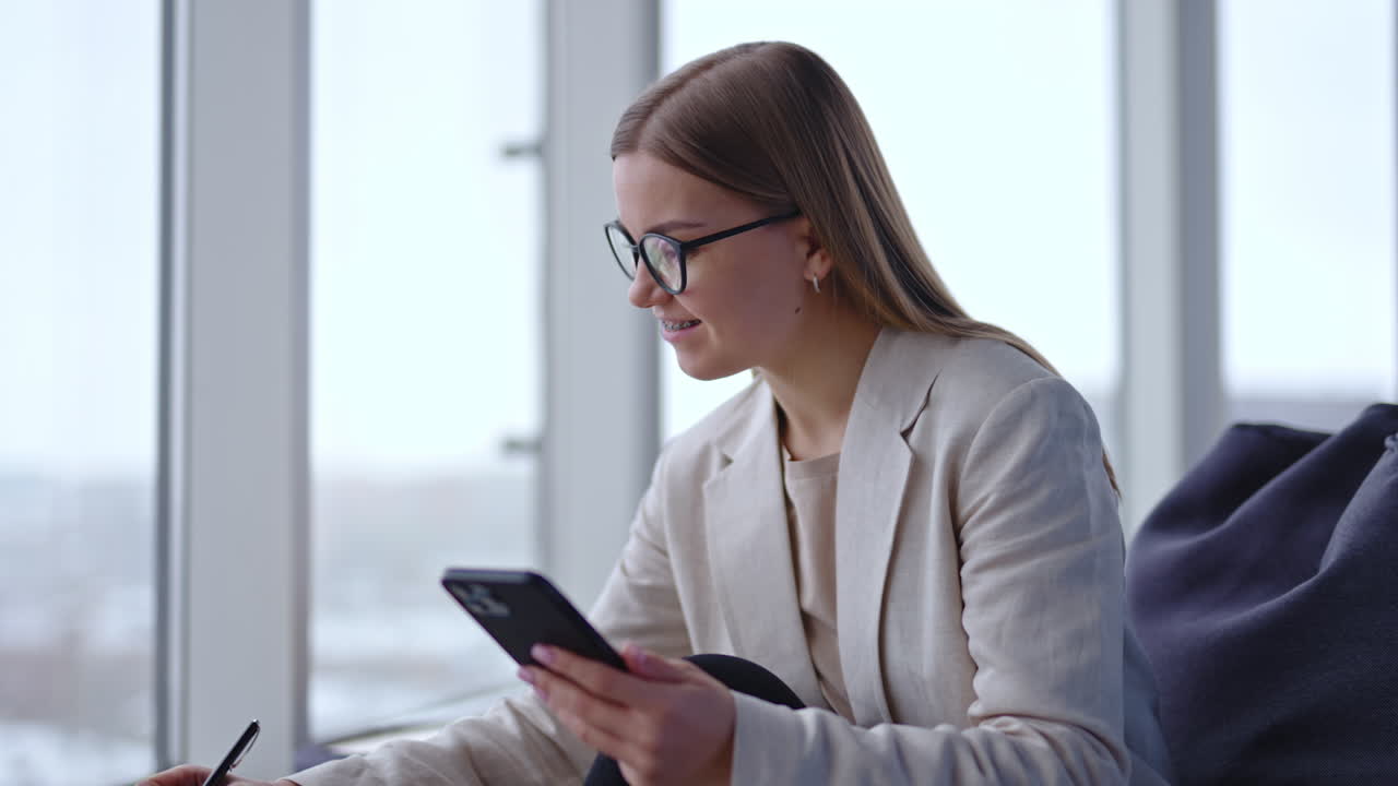 Woman in meeting using smartphone in modern office