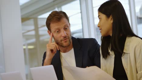 Business-colleagues-discussing-over-document-in-conference-room-4k