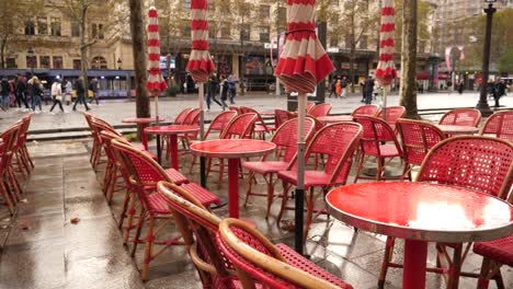 wet red tables poured by raindrops empty closed outdoors restaurant court in paris city center champs elysees