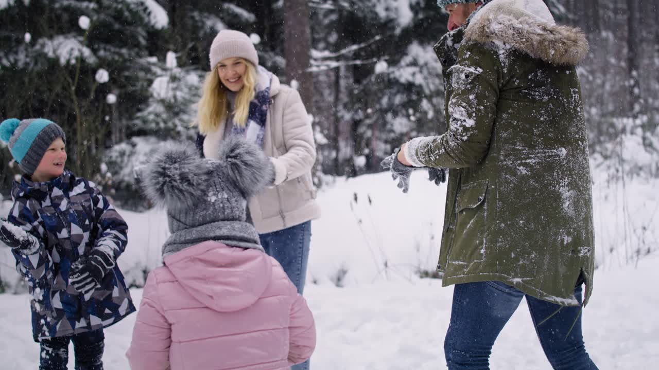video de mano de la familia teniendo una pelea de bolas de nieve