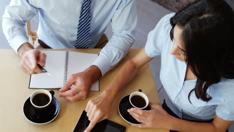 woman and businessman interacting with each other while using digital tablet