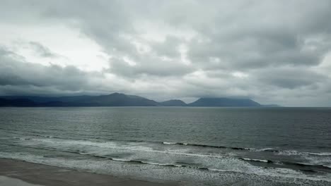 view of the edge of the ocean in ireland in bad weather, waves and stormy sky