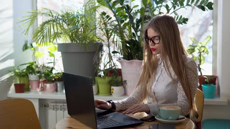 mujer trabajando en una computadora portátil en un café