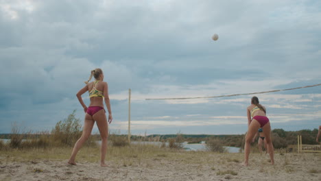 woman player of beach volleyball is serving ball slow-motion shot of passing and attacking match of two ladies teams