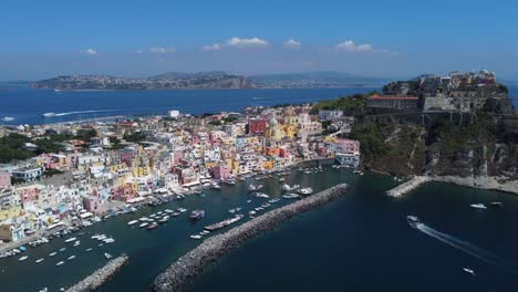 marina corricella port on procida islands off the coast of naples, waterfront colourful housing and church, italy, aerial shot