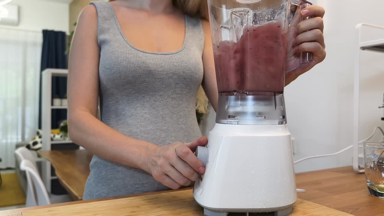 una mujer haciendo un batido púrpura.