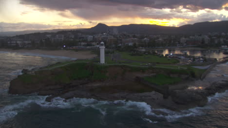 lighthouse tower on australia cliff coastline at sunset - aerial orbit