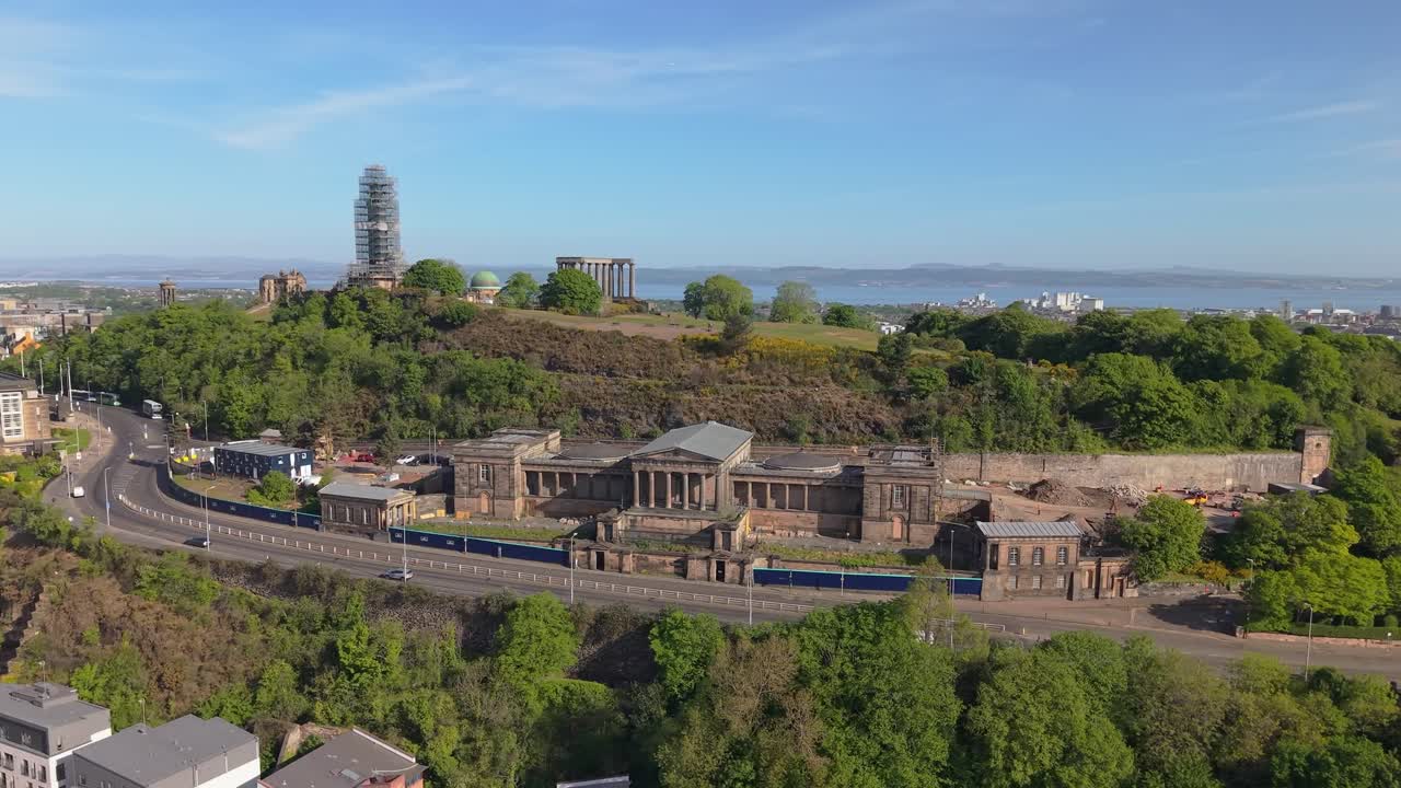 Drone footage unveils Calton Hill in Edinburgh, capturing its monuments and panoramic views of the cityscape under soft natural light