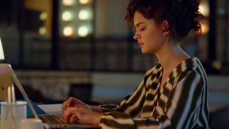 beautiful woman typing on computer in coworking. girl working on laptop indoors.