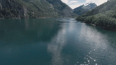 blue lake water of tafjord area in norway, aerial fpv drone view