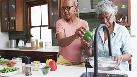 Felices-Amigas-Afroamericanas-Mayores-Cocinando-En-La-Cocina,-Lavando-Verduras,-Cámara-Lenta