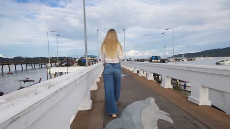 woman walking on a pier at a coastal port