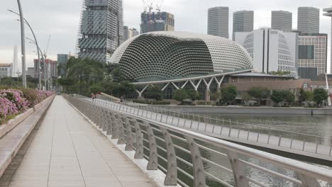 vista de la pasarela a lo largo del área de la bahía del puerto deportivo con torre de edificio financiero de oficinas de rascacielos de gran altura en el distrito central de negocios de la ciudad de singapur, moderno edificio del centro de la ciudad de metrópolis