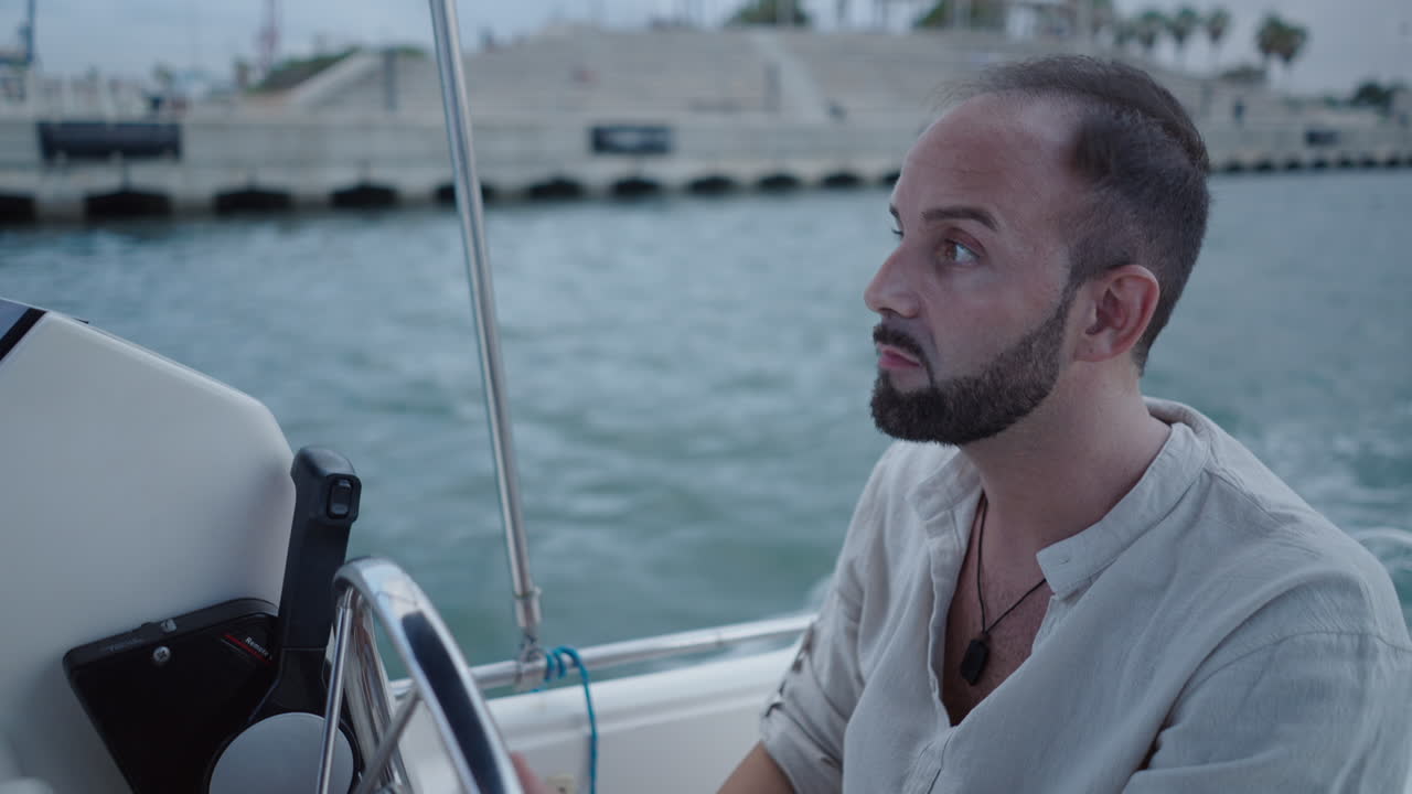 Man steering a boat in a harbor or canal