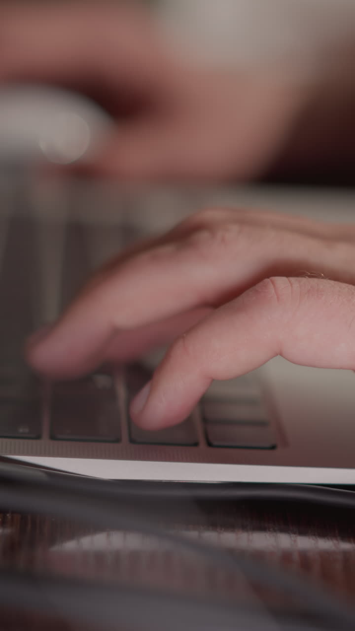 Close-up of a hand typing on a laptop keyboard, with the background blurred to emphasize the action. hand's movement and the focus on the task