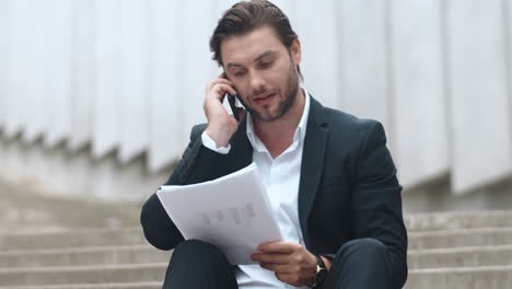 Business-man-talking-on-mobile-phone.Employee-celebrating-victory-with-documents