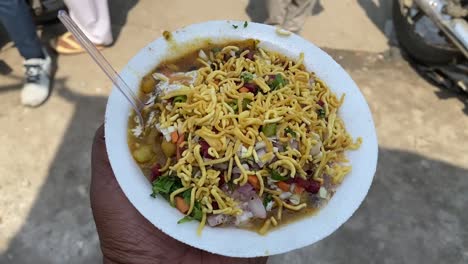 close up shot of aloo tikki chaat is a mouth watering indian snack , served with chana, namkeen, tomato ketchup or imli chutney