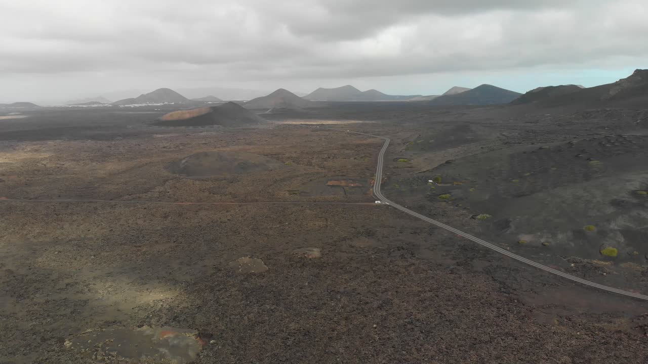 vista aérea de un paisaje lunar con una furgoneta blanca al lado de la carretera