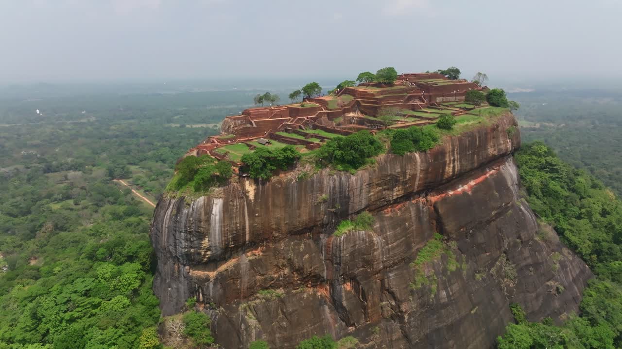 Sri Lanka, oversiktsbilde i luftperspektiv av Sigiriya-monolitten med nærliggende våtmarker og skog, som viser festningstoppen og omkringliggende grønne vidde