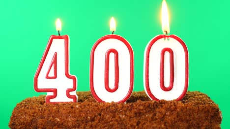 cake with the number 400 lighted candle. chroma key. green screen. isolated
