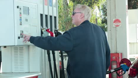 man operating fuel pump at gas station