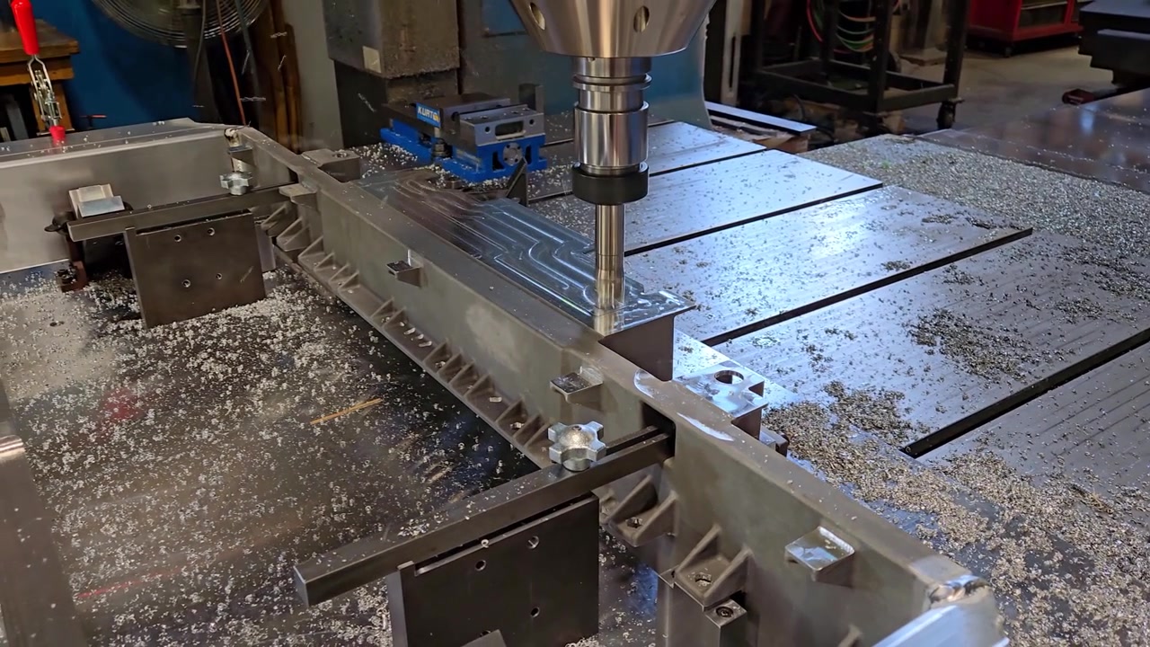 Fresatrice verticale che crea un prototipo in alluminio per un vassoio batteria di veicolo.