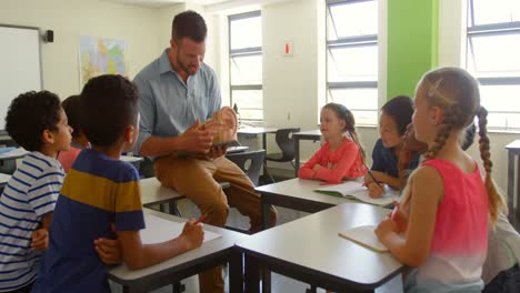profesor masculino caucásico adulto explicando el modelo anatómico en el aula de la escuela 4k