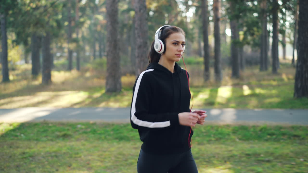 mujer corriendo en el parque con auriculares